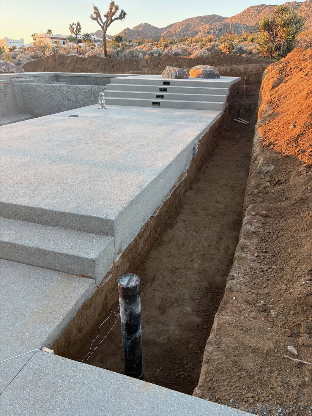 Excavated trench along the concrete deck for the gabion wall footing