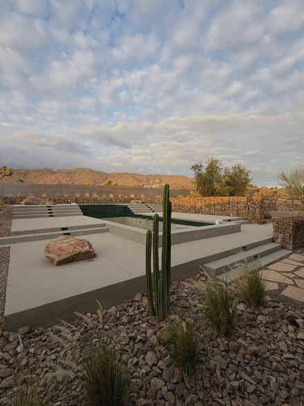 Modern pool and spa framed by a gabion retaining wall