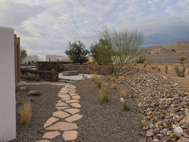 Stone path through a gravel garden bed with desert hillside views